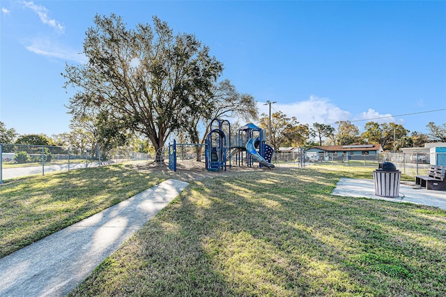 view of property's community featuring fence, playground community, and a yard