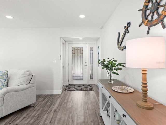 foyer entrance featuring baseboards, wood finished floors, and recessed lighting