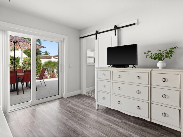 interior space featuring wood finished floors, baseboards, and a barn door