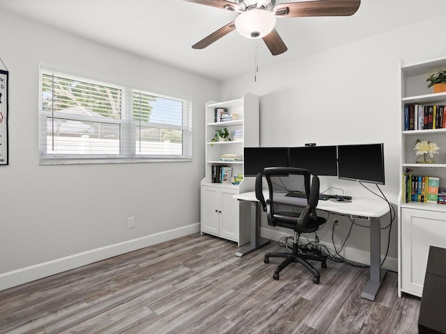 home office featuring light wood-style floors, ceiling fan, and baseboards