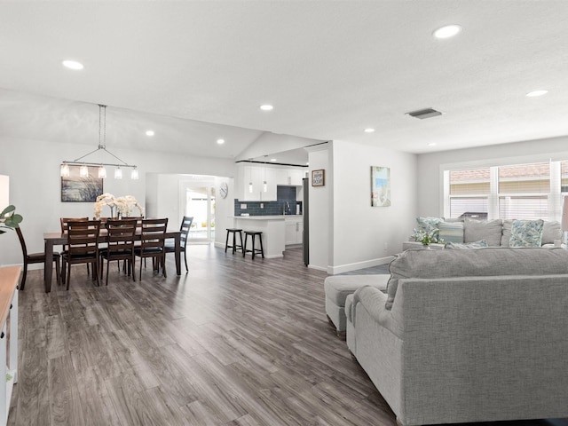 living room featuring recessed lighting, visible vents, plenty of natural light, and wood finished floors