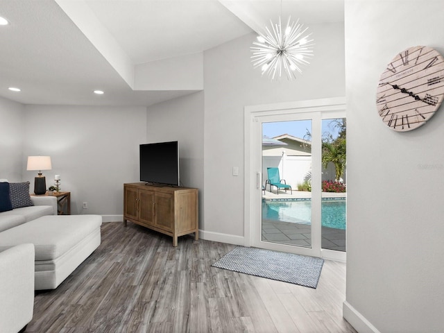 living area featuring recessed lighting, a notable chandelier, baseboards, and wood finished floors