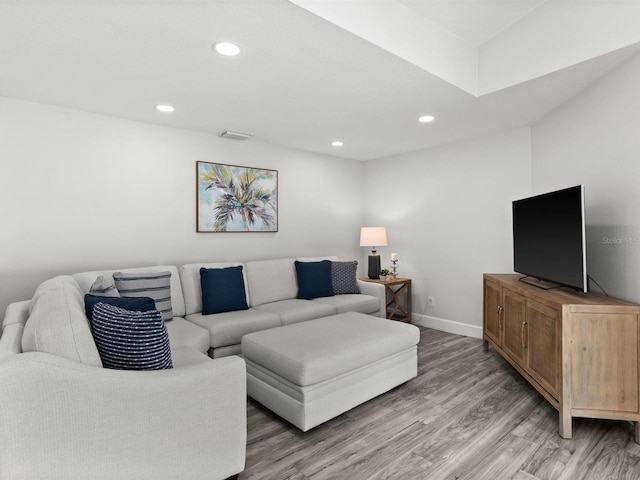 living area with light wood-type flooring, visible vents, baseboards, and recessed lighting