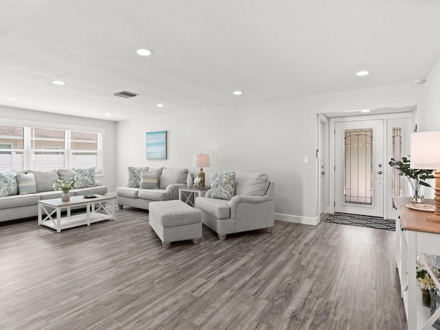 living room with baseboards, visible vents, wood finished floors, and recessed lighting