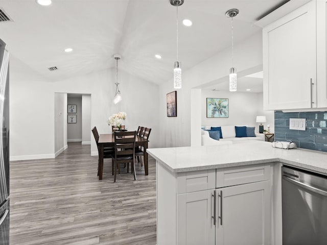 kitchen featuring lofted ceiling, light wood-style floors, white cabinets, stainless steel dishwasher, and decorative backsplash