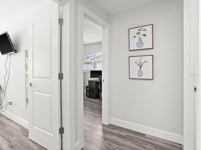 hall with wood finished floors and baseboards