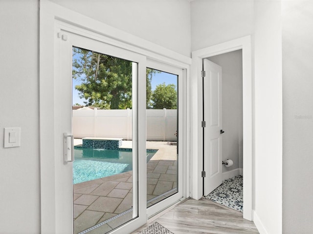 doorway featuring baseboards and wood finished floors