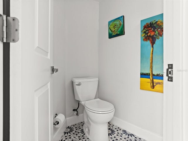 bathroom with tile patterned flooring, baseboards, and toilet