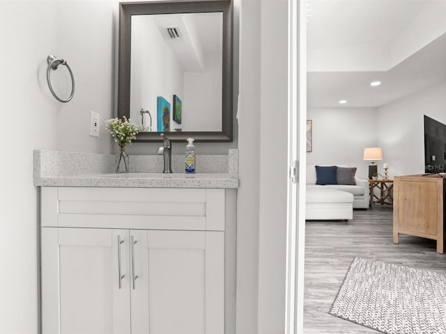 bathroom featuring recessed lighting, visible vents, vanity, and wood finished floors