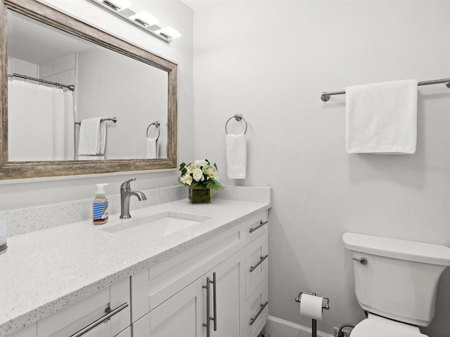 full bath featuring vanity, toilet, and baseboards