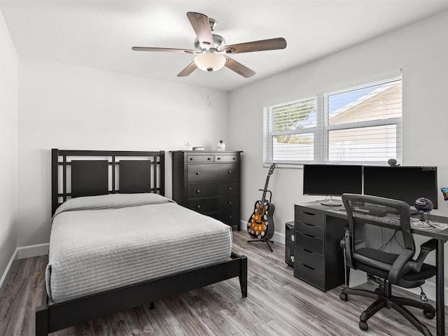 bedroom with ceiling fan, baseboards, and wood finished floors