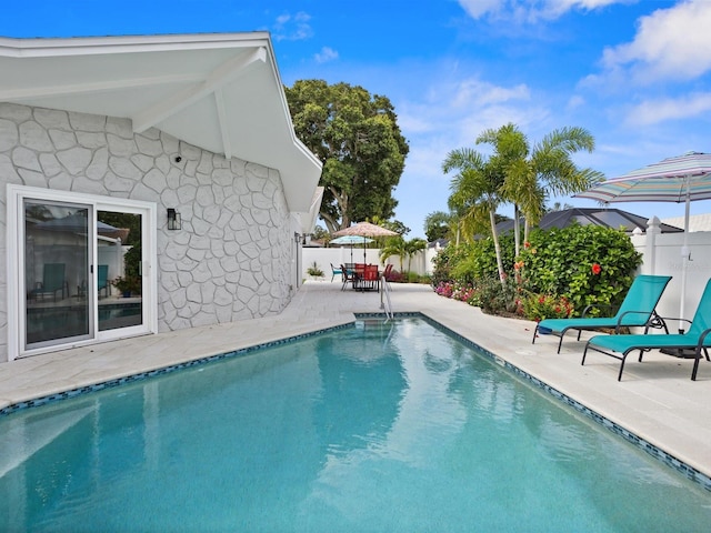 view of pool with outdoor dining space, a patio area, a fenced backyard, and a fenced in pool