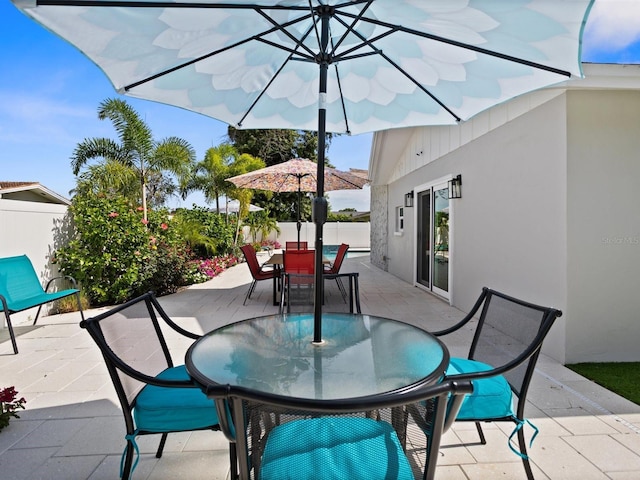 view of patio featuring fence and outdoor dining space