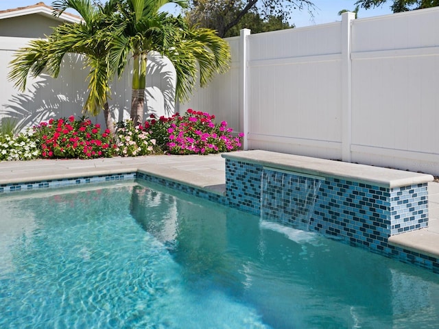 view of swimming pool featuring fence