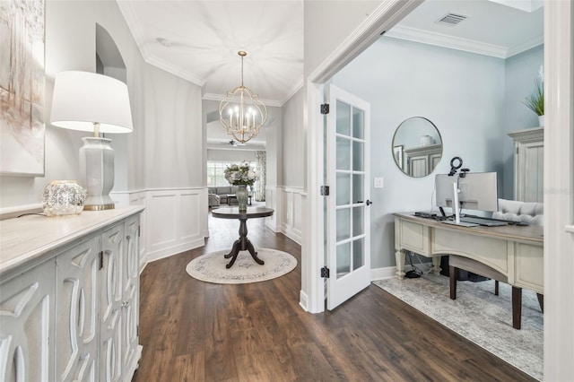 bathroom featuring crown molding, a notable chandelier, a decorative wall, wainscoting, and wood finished floors