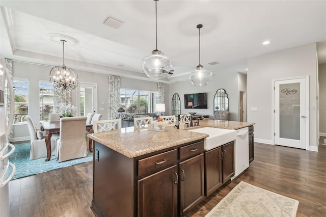 kitchen featuring dark wood-style floors, dark brown cabinets, a tray ceiling, and white dishwasher