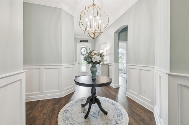 foyer entrance with dark wood-type flooring, arched walkways, and crown molding