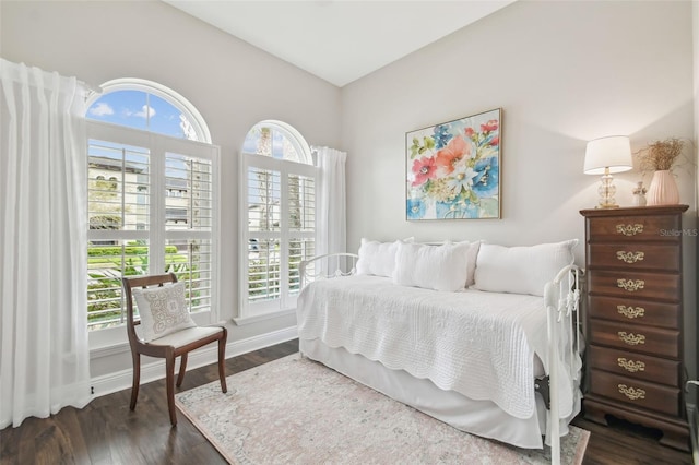 bedroom with multiple windows, baseboards, and dark wood-style flooring