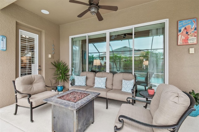 view of patio with ceiling fan and an outdoor living space with a fire pit