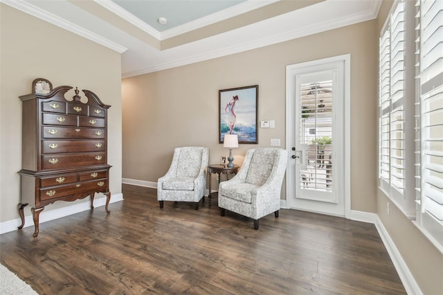 sitting room featuring a tray ceiling, ornamental molding, dark wood-style flooring, and baseboards