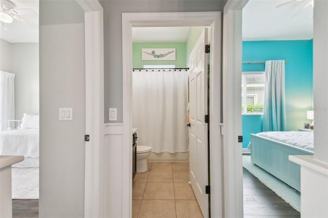 full bathroom with toilet, connected bathroom, ceiling fan, vanity, and tile patterned flooring