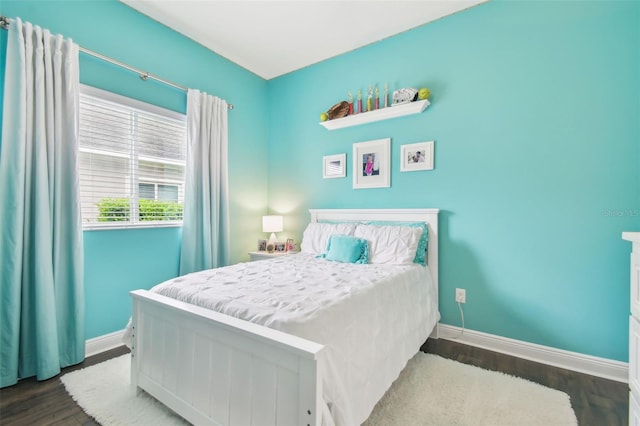 bedroom with wood finished floors and baseboards