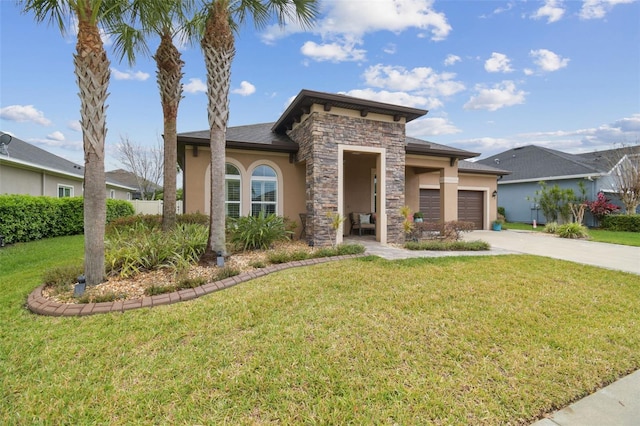 prairie-style home with a garage, stone siding, concrete driveway, stucco siding, and a front yard