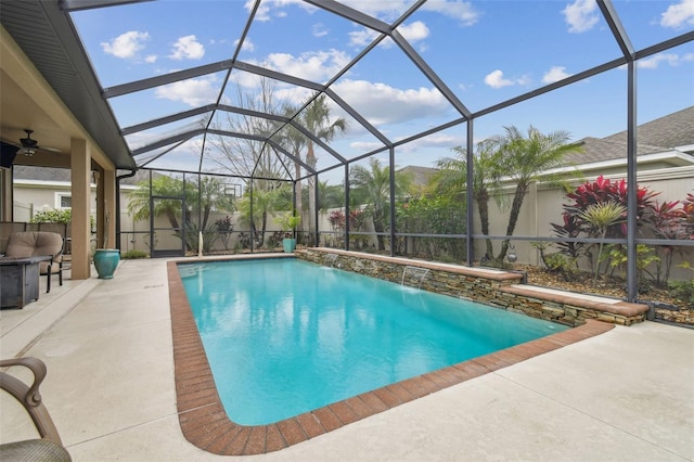 outdoor pool with glass enclosure, a patio area, fence, and a ceiling fan