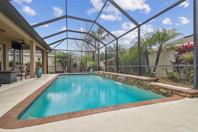 pool featuring a lanai, a patio area, and a ceiling fan