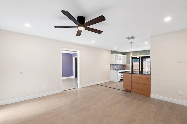 810 22nd St N, Saint Petersburg, FL 33713 - kitchen featuring visible vents, baseboards, backsplash, light wood finished floors, and dark countertops