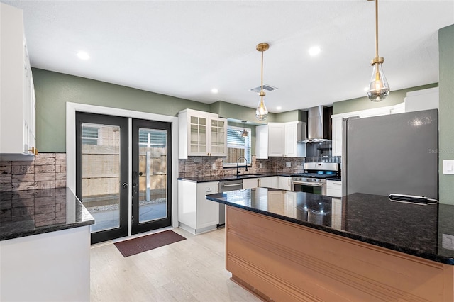810 22nd St N, Saint Petersburg, FL 33713 - kitchen featuring decorative backsplash, appliances with stainless steel finishes, a sink, a peninsula, and wall chimney exhaust hood