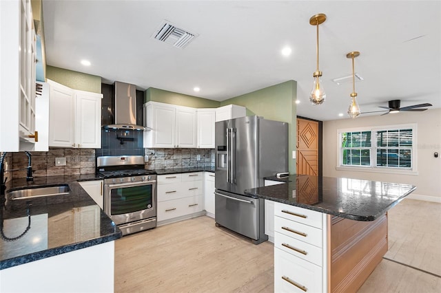 810 22nd St N, Saint Petersburg, FL 33713 - kitchen with stainless steel appliances, a sink, visible vents, wall chimney range hood, and light wood finished floors