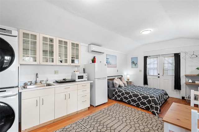 810 22nd St N, Saint Petersburg, FL 33713 - bedroom with lofted ceiling, stacked washer and dryer, a sink, freestanding refrigerator, and a wall mounted air conditioner