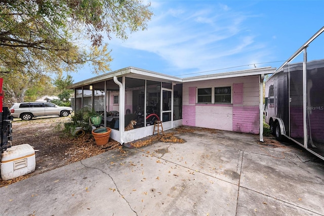 rear view of house featuring a sunroom