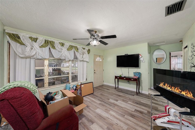 9048 94th St, Seminole, FL 33777 - living area featuring visible vents, wood finished floors, baseboards, a textured ceiling, and a ceiling fan