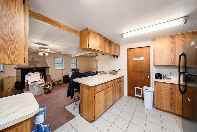 9048 94th St, Seminole, FL 33777 - kitchen with freestanding refrigerator, a peninsula, open floor plan, light countertops, and a ceiling fan
