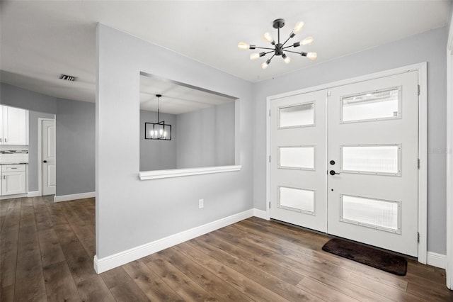 entrance foyer with a chandelier, dark wood-style flooring, and visible vents