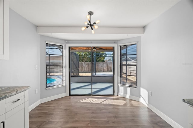 doorway to outside featuring dark wood-style floors, baseboards, and an inviting chandelier