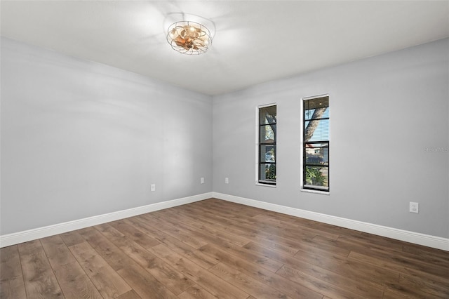 unfurnished room featuring wood finished floors and baseboards