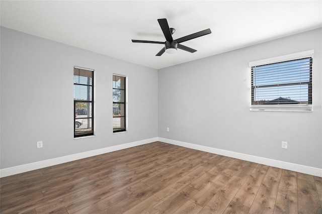 unfurnished room featuring a ceiling fan, baseboards, and wood finished floors