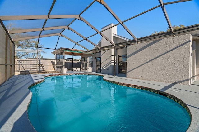 view of swimming pool with a patio area, a fenced backyard, glass enclosure, and a fenced in pool