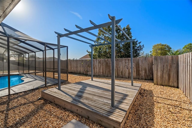 view of patio with a fenced in pool, glass enclosure, a fenced backyard, and a wooden deck