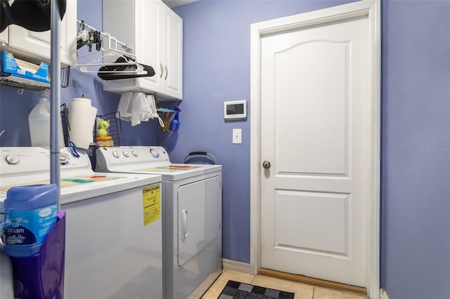 washroom with washer and dryer, cabinet space, baseboards, and light tile patterned floors