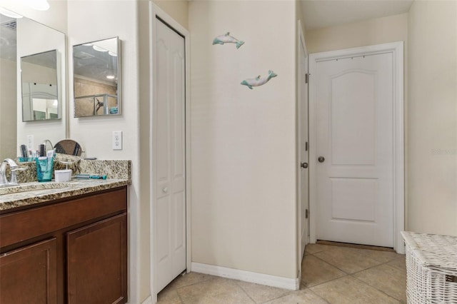 bathroom featuring a closet, tile patterned flooring, vanity, and baseboards