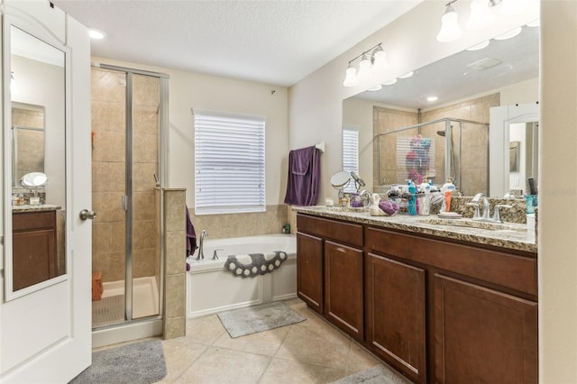 full bath featuring a stall shower, a textured ceiling, vanity, tile patterned flooring, and a bath