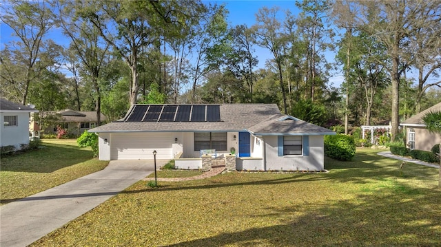 single story home featuring roof mounted solar panels, stucco siding, driveway, and a front yard