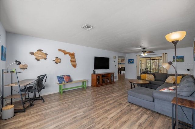 living room featuring visible vents, baseboards, ceiling fan, and wood finished floors