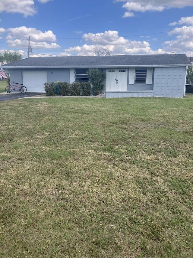 single story home featuring a garage, driveway, and a front yard