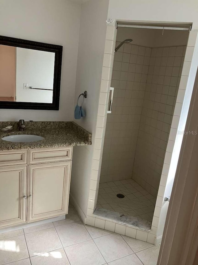 full bathroom with a stall shower, vanity, and tile patterned floors