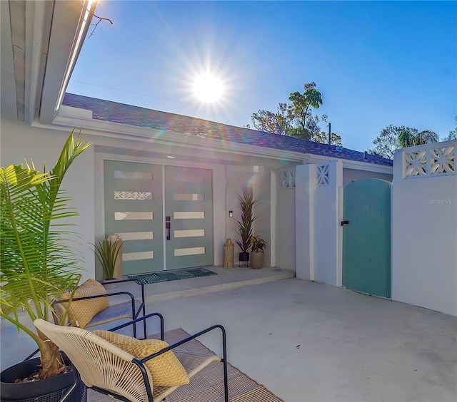 doorway to property with a gate and stucco siding